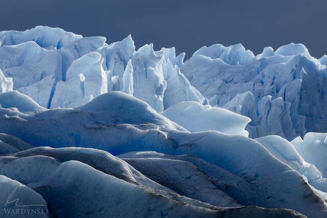 Contemporary fine art landscape photograph of the Perito Moreno glacier in Argentina. The image is minimalistic in nature with beautiful blue layers of ice.