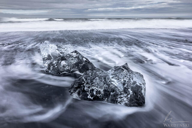 A shard of glacial ice lies on the black sand of Diamond Beach in Iceland. This fine art photograph is for art collectors who love landscape photography 