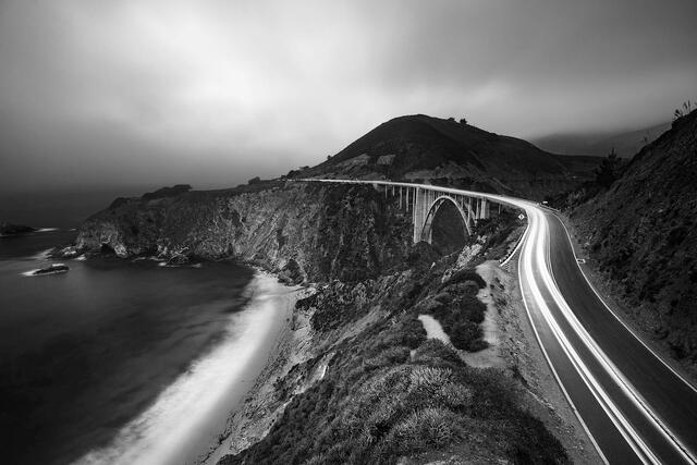 Black and White photograph of headlights streaking over Bixby Bridge in Big Sur California