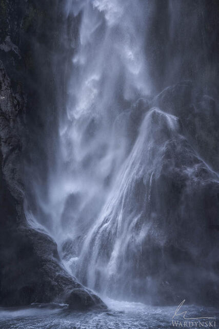 Dramatic photograph of a water crashing on rocks in Milford Sound New Zealand. 